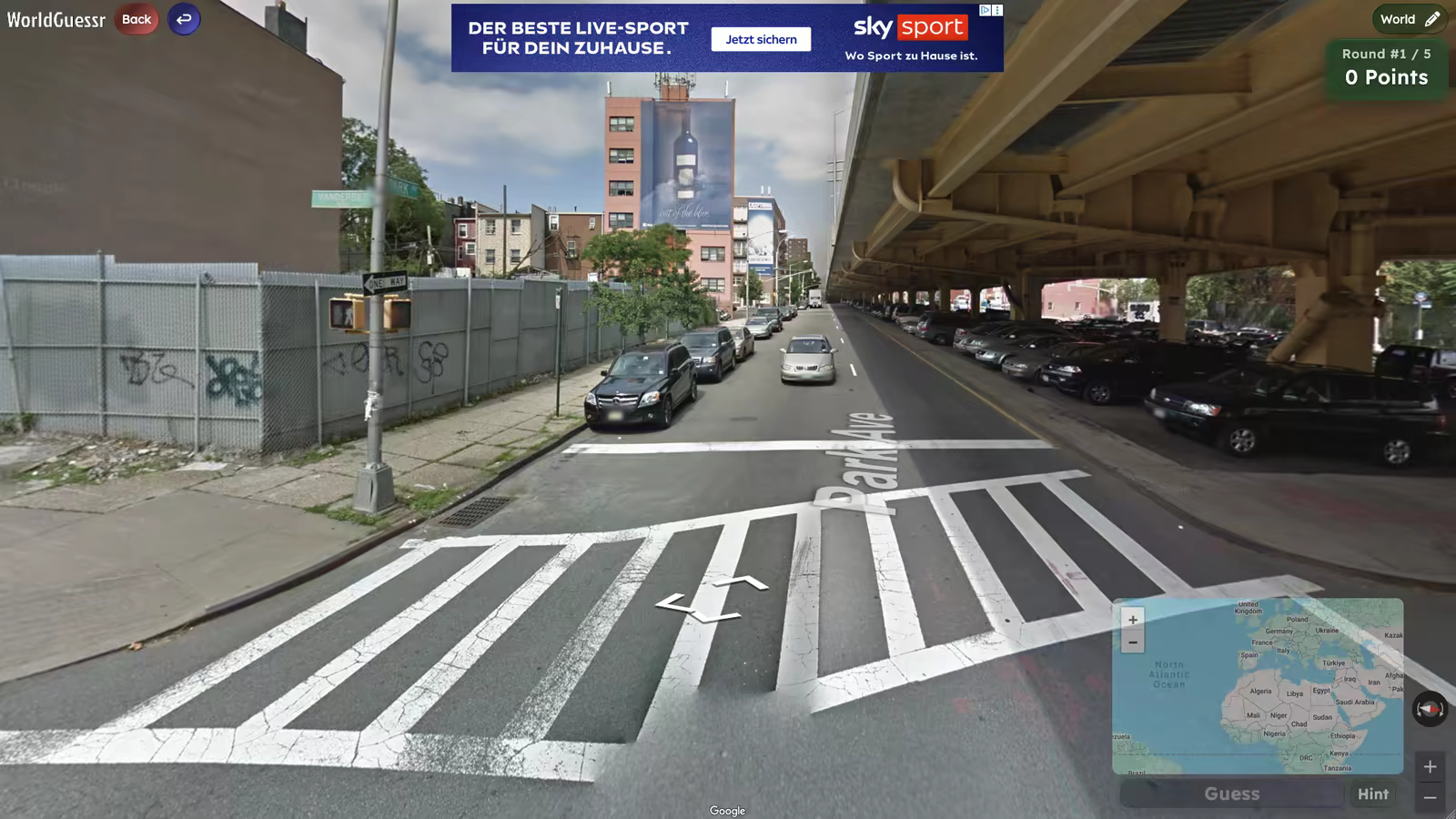 A WorldGuessr round at a city crossing beneath an elevated roadway